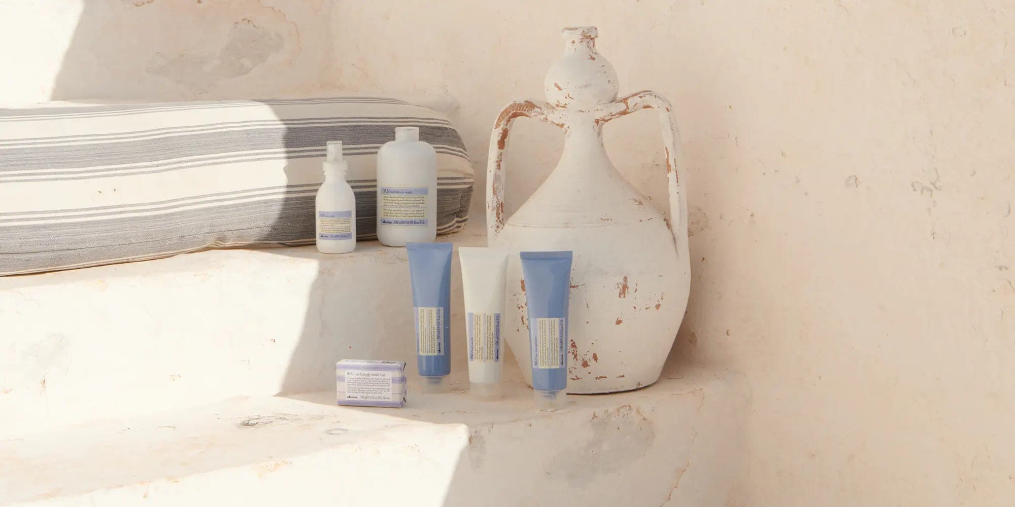 Davines SU hair-care products on sunlit stone steps